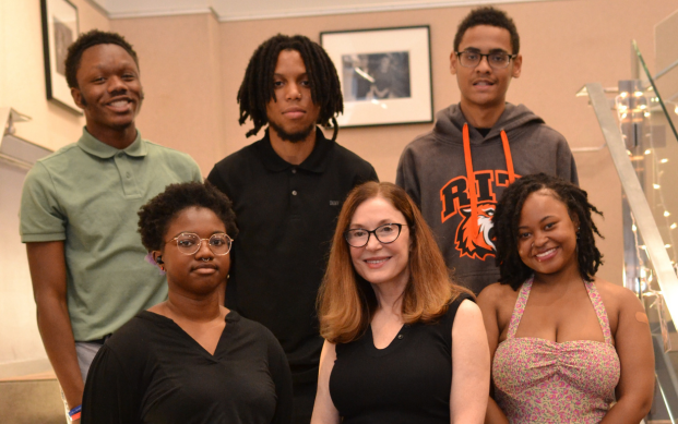 Isaiah (back center) and Kimberly (front right) celebrate their high school graduation with their peers.