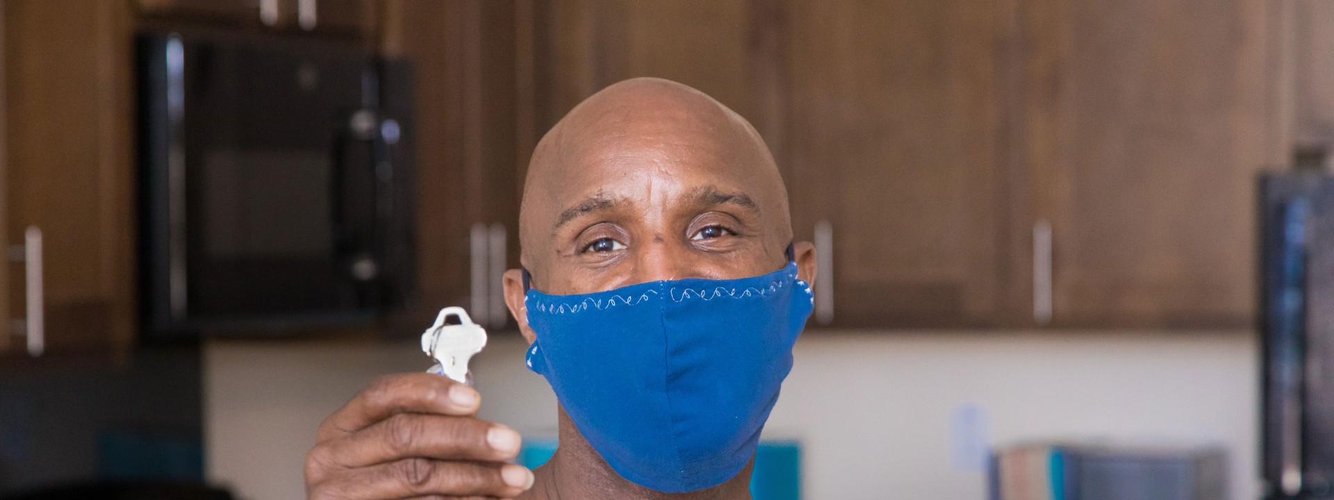 Man holding key to his new affordable apartment