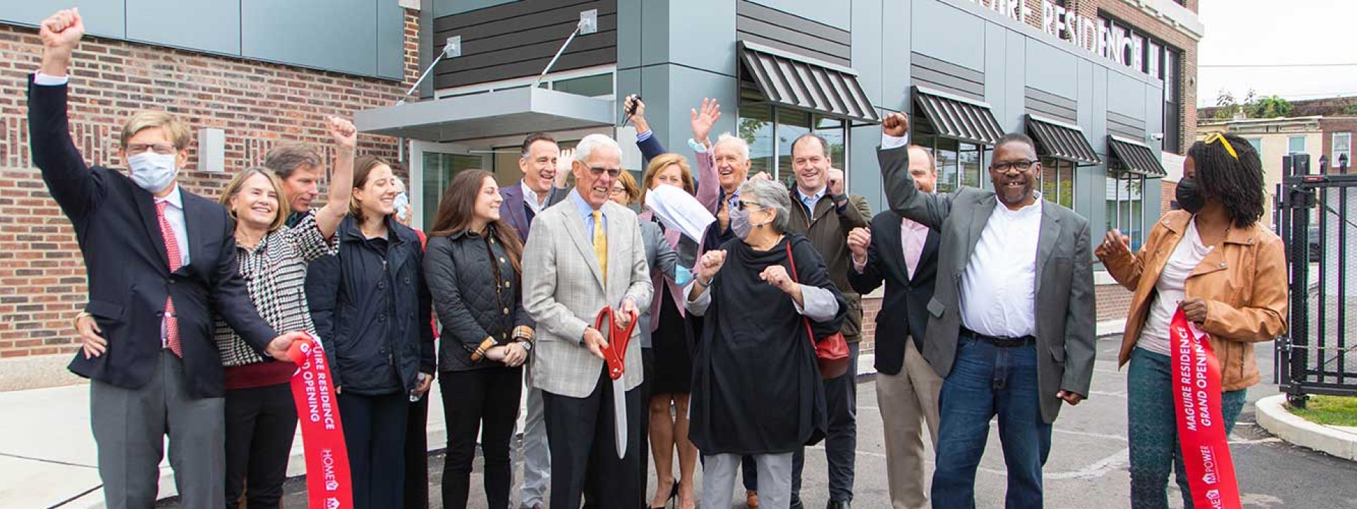 Group cutting the ribbon at Project HOME's Maguire Residence