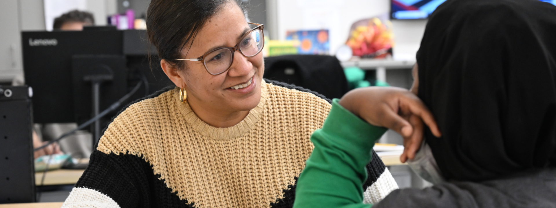 A woman talking and smiling at another person.