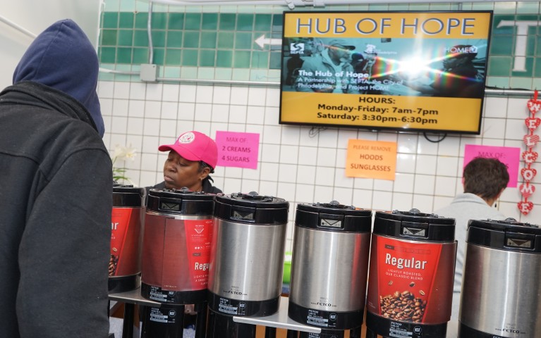 A volunteer serving coffee at the Hub of Hope