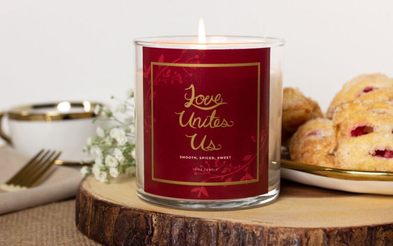 Image of Love Unites Us Candle lit on dinner table.