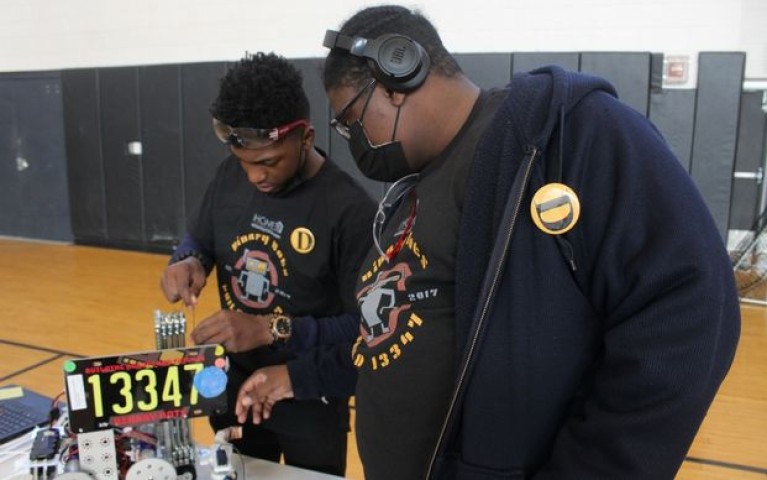 Two students working on a robot 