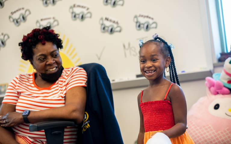 A teacher smiles at her young student