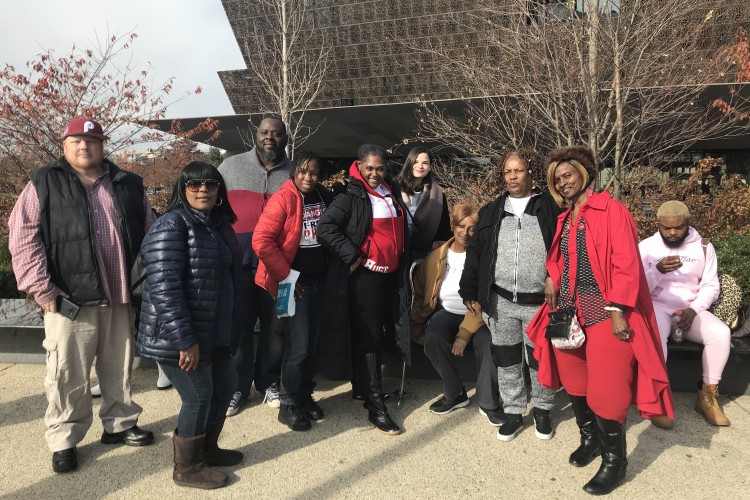 A number of people standing in front of the African-American Museum in Washington DC 