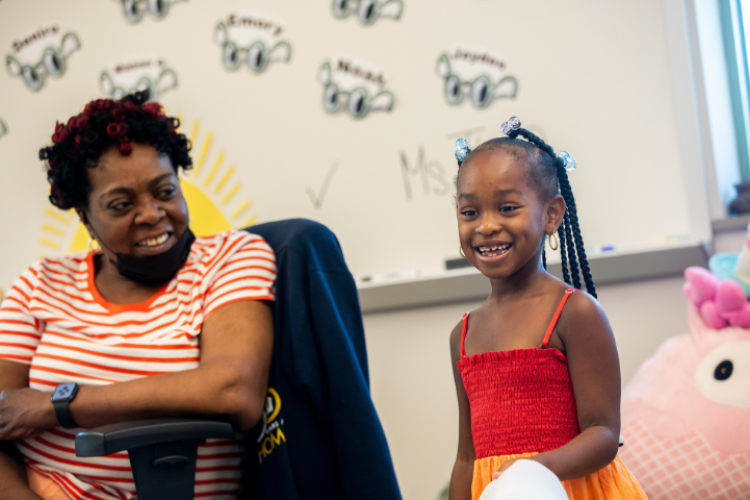 A teacher smiles at her young student