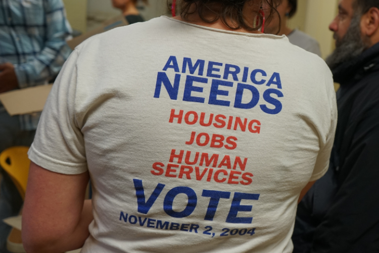 Person wearing a t-shirt with a slogan about voting.