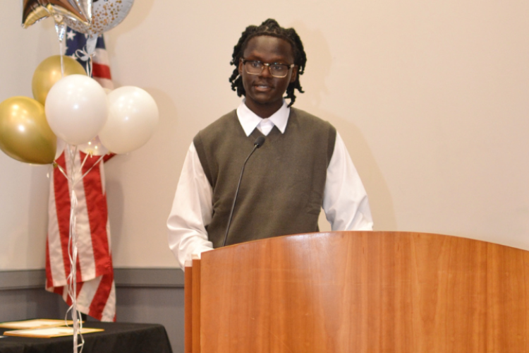 A young man standing at a podium delivering a speech